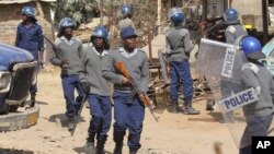 FILE: Armed Zimbabwean police battle rioters in Harare, Monday, July, 4, 2016.