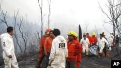 Rescue team members carry the body of a firefighter after a forest fire near Temuco city, south of Santiago, January 5, 2012.