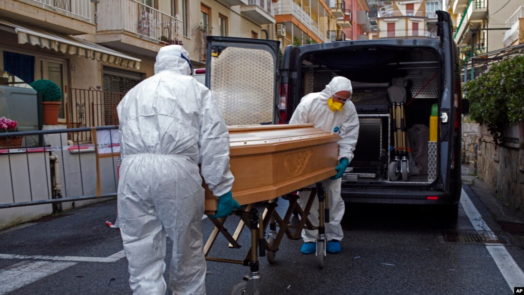Anggota staf medis yang mengenakan baju pelindung, membawa peti jenazah Assunta Pastore, 87 tahun, salah satu dari grup turis lansia di kawasan Lombardia, yang dites positif virus korona, Minggu, 1 Maret 2020. (Foto: Reuters)