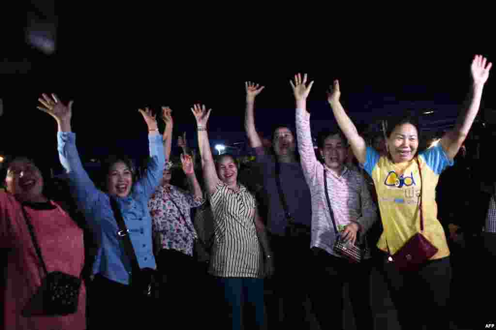 Volunteers celebrate at a makeshift press center in Mae Sai district of Chiang Rai province after the twelve boys and their football coach were rescued.