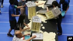 Election staff members open ballot boxes for vote counting in the upper house elections at a ballot counting center in Tokyo, Japan, July 10, 2016. 