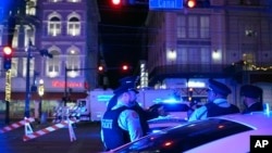 Police officers stand near the scene where a vehicle drove into a crowd on New Orleans' Canal and Bourbon streets, Jan. 1, 2025. 