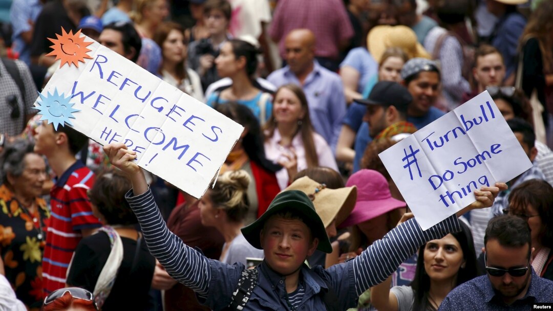FILE - Demonstrators hold aloft placards during a rally in support of refugees that was part of a national campaign in central Sydney, Australia, Oct. 11, 2015. 