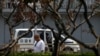 FILE - A man walks by a police van in Beijing, China, June 4, 2024.