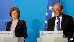 French Minister for Foreign Affairs Jean-Yves Le Drian, right, and French Defense Minister Florence Parly give an official statement in the press room after attending an emergency meeting with French President Emmanuel Macron at the Elysee Palace, in Paris, France, Saturday, April 14, 2018.