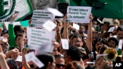 Ariel Heredia, quien se identifica como no binario, sostiene un cartel en defensa de cupo laboral para transgéneros en una protesta frente al Ministerio de Economía en Buenos Aires para exigir la reincorporación de trabajadores estatales despedidos, el 5 de abril de 2024. 