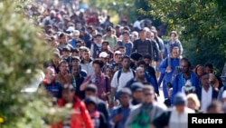 FILE - Migrants walk toward the Austrian border from Hegyeshalom, Hungary, Sept. 23, 2015. Slovakia has fiercely resisted EU efforts to cope with a big influx of mainly Muslim migrants into Europe since 2015.