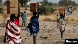 Women carry boxes of nutritional food delivered by the U.N. World Food Program, in Rubkuai, South Sudan, Feb. 16, 2017.