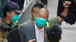 FILE - Democracy advocate Jimmy Lai, center, leaves a Hong Kong court, Feb. 9, 2021.