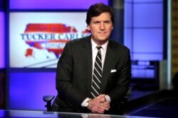 FILE - Tucker Carlson, host of "Tucker Carlson Tonight," poses for photos in a Fox News Channel studio, in New York, March 2, 2017.