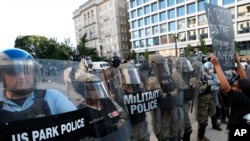 Police clear the area around Lafayette Park and the White House as demonstrators gather to protest the death of George Floyd, June 1, 2020, in Washington. Floyd died after being restrained by Minneapolis police officers. 