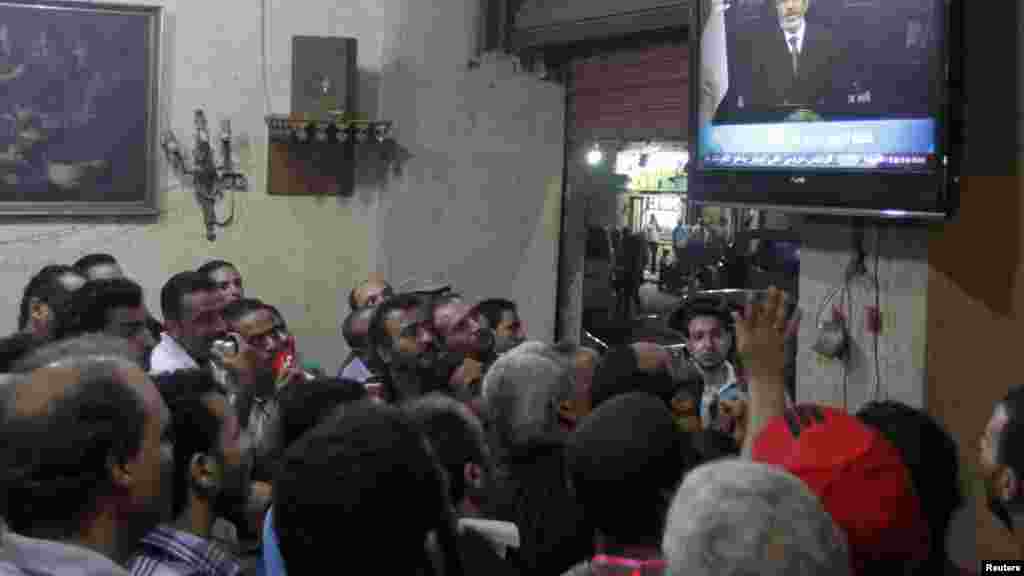 Anti-President Mohamed Morsi protesters watch a speech by him on TV at a cafe in Tahrir Square in Cairo, July 2, 2013.