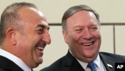 Dari kiri, Menteri Luar Negeri Turki Mevlut Cavusoglu dan Menteri Luar Negeri AS Mike Pompeo berfoto sebelum menghadiri pertemuan menteri luar negeri NATO di markas NATO, di Brussels, Belgia, 27 April 2018.