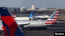 Sebuah pesawat JetBlue mendarat Bandara Nasional Ronald Reagan Washington di Arlington, Virginia, sementara tampak pesawat United Airlines, American Airlines, dan Delta Airlines, 25 Januari 2025. (Foto: Jim Urquhart/Reuters)