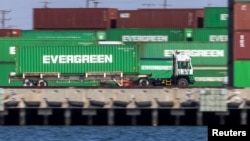 Un camionero pasa frente a contenedores en el congestionado puerto de Los Ángeles en San Pedro, California, EE. UU., 29 de septiembre de 2021.