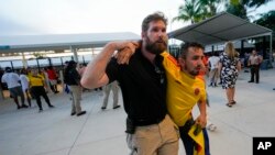 Un agente de seguridad asiste a un aficionado que esperaba entrar al estadio para la final de la Copa América entre Argentina y Colombia el domingo 14 de julio del 2024.