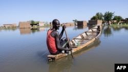 Un homme navigue sur une pirogue entre les maisons du quartier Tougoude, au sud-est du 9ème arrondissement de Ndjamena, inondé par le fleuve Logone, au Tchad le 8 octobre 2024. 