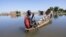 Un homme navigue sur une pirogue entre les maisons du quartier Tougoude, au sud-est du 9ème arrondissement de Ndjamena, inondé par le fleuve Logone, au Tchad le 8 octobre 2024. 
