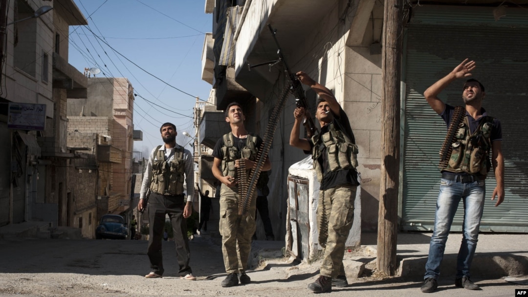 Free Syrian Army fighters train a gun on a Syrian war plane in the Bustan Pasha neighborhood of Syria's northern city of Aleppo, Aug. 23, 2012. 