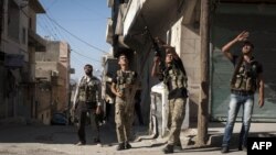 Free Syrian Army fighters train a gun on a Syrian war plane in the Bustan Pasha neighborhood of Syria's northern city of Aleppo, Aug. 23, 2012. 