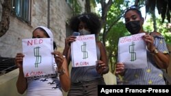 Pro-government demonstrators hold signs outside the Municipal Assembly headquarters in Old Havana, on Oct. 12, 2021. 