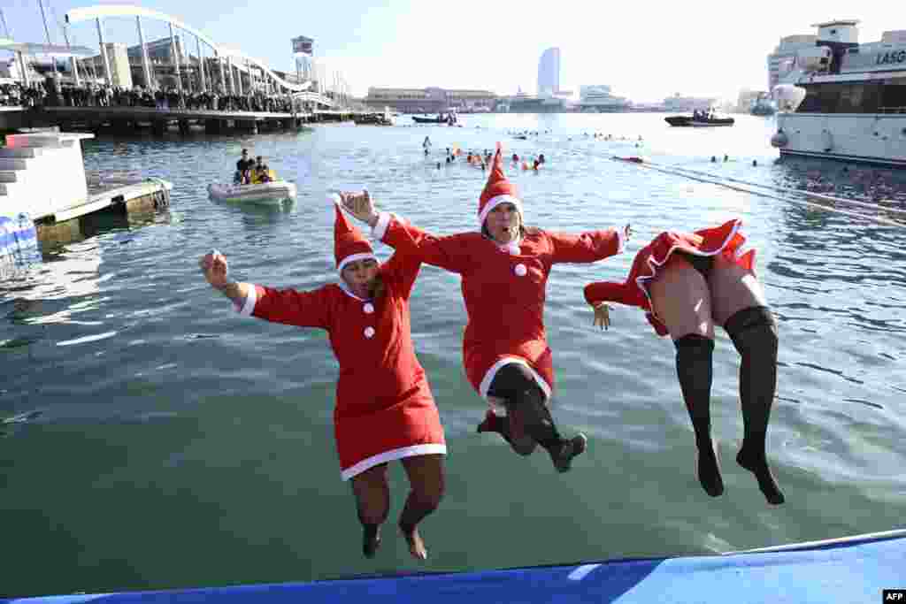 Participants in Santa costumes jump into the water during the 115th edition of the Copa Nadal (Christmas Cup) swimming race in Barcelona&#39;s Port Vell, Spain, Dec. 25, 2024.