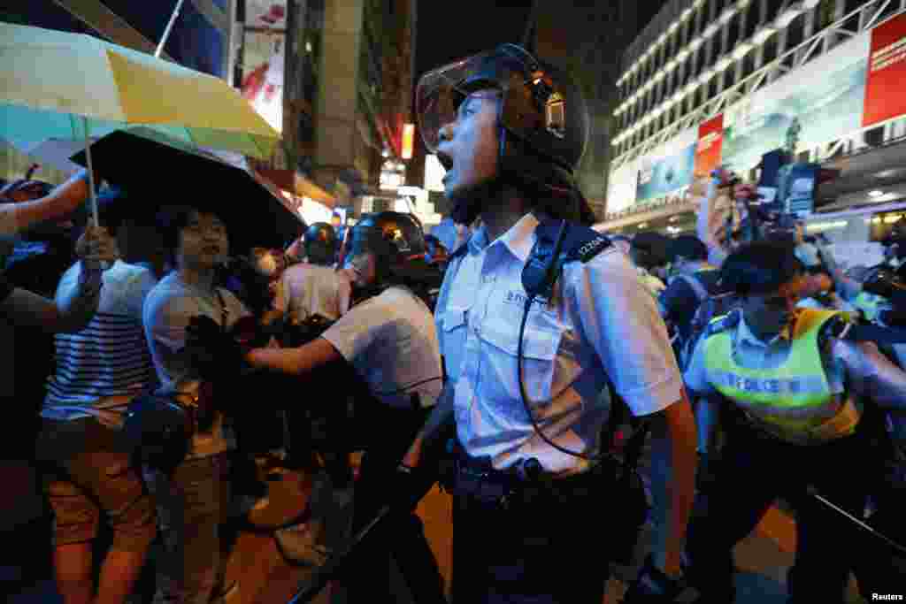 A riot policeman yells during a confrontation with protesters at Mongkok shopping district in Hong Kong. Police used pepper spray and baton charged crowds of pro-democracy protesters on Friday evening as tension escalated. 