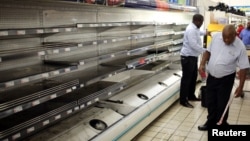 FOTO ARSIP: Seorang pekerja memandang rak-rak yang kosong setelah menyingkirkan produk-produk daging olahan di toko Pick n Pay di Johannesburg, Afrika Selatan, 5 Maret 2018 (foto: REUTERS/Siphiwe Sibeko/Foto Arsip)