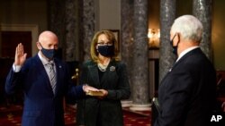 Mark Kelly, D-Ariz., with his wife, former Rep. Gabby Giffords, D-Ariz., joins the U.S. Senate, Dec. 2, 2020, with Vice President Mike Pence officiating, in the Old Senate Chamber on Capitol Hill in Washington.