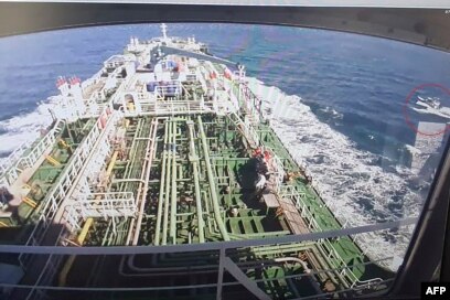 Rekaman CCTV kapal Hankuk Chemi menampilkan perahu Pengawal Revolusi Iran (dalam lingkaran merah) saat ditayangkan di layar perusahaan pemilik kapal tanker DM Shipping, di Busan, 4 Januari 2021. (Foto: YONHAP / AFP)