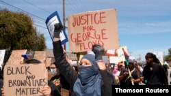 Protesters holding banners march toward the L.A. County Sheriff's Department during a rally against the death in Minneapolis police custody of George Floyd, in Los Angeles, May 30, 2020. 