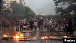 Opposition supporters build a barricade while clashing with riot security forces during a rally against President Nicolas Maduro in Caracas, Venezuela, May 10, 2017. 