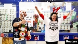 Owner Jose Maria Nogales and his wife Paloma Rodriguez celebrate selling the winning ticket of the biggest prize in Spain's Christmas lottery "El Gordo" (The Fat One) in Seville, Spain, December 22, 2019. 