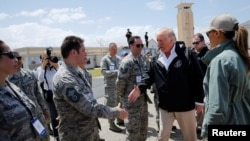 El presidente Donald Trump saluda a soldados al llegar a Puerto Rico para evaluar los daños dejados por el huracán María en la isla y los esfuerzos de recuperación. Oct. 3, 2017.