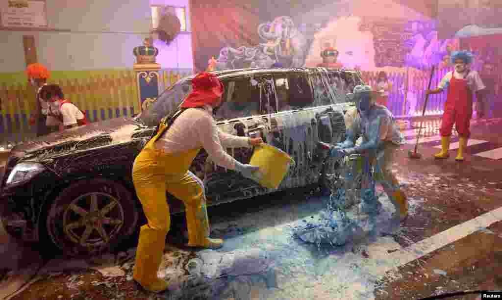 Clowns with the circus Krone joke around at the car-washing business owned by the Krone circus, which is not allowed to perform officially due to the COVID-19 outbreak, in Munich, Germany.
