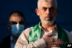 FILE - Yahya Sinwar, Palestinian leader of Hamas in the Gaza Strip, places his hand over his heart after greeting supporters at a rally on May 24, 2021, in Gaza City, the Gaza Strip.