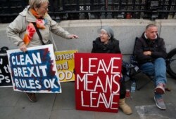 Brexit supporters display their signs in front of Parliament in London, Oct. 23, 2019.