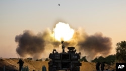 An Israeli artillery unit fires shells towards targets in Gaza Strip, at the Israeli Gaza border, May 19, 2021.