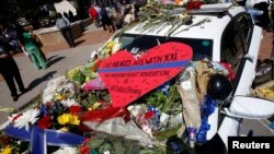 FILE - A heart is pictured on a police car that makes up part of a makeshift memorial at police headquarters following the multiple police shooting in Dallas, Texas, July 8, 2016. 