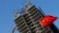 Bendera nasional China berkibar di lokasi pembangunan kompleks perumahan baru di Beijing, 4 November 2013. (Foto: Reuters)