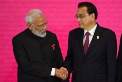 India's Prime Minister Narendra Modi, left, shakes hands with China's Premier Li Keqiang during the 3rd Regional Comprehensive Economic Partnership (RCEP) Summit in Bangkok, Nov. 4, 2019.