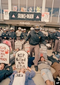 ФАЙЛ — Демонстранты из организации ACT UP, возмущенные реакцией федерального правительства на кризис со СПИДом, протестуют перед штаб-квартирой Управления по санитарному надзору за качеством пищевых продуктов и медикаментов в Роквилле, штат Мэриленд, 11 октября 1988 года.