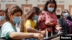 Warga Kristen Irak merayakan Paskah di luar gereja St. Elya Chaldean di tengah pembatasan COVID-19 di Irak, Minggu (4/4).
