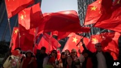 Pro-Beijing supporters wave the Chinese national flags during a rally in Hong Kong, Dec. 7, 2019.