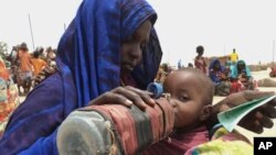 Seorang ibu memberi minum anaknya sementara menunggu pembagian makanan di Ogaden, Somalia. (Foto: Dok)