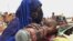 FILE - A mother quenches her malnourished child's thirst while waiting for food handouts at a health center in drought-stricken remote Somali region of Eastern Ethiopia.
