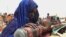 FILE - A mother quenches her malnourished child's thirst while waiting for food handouts at a health center in drought-stricken remote Somali region of Eastern Ethiopia, also known as the Ogaden.