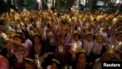 Well-wishers hold lit candles and portraits of Thailand's King Bhumibol Adulyadej at Siriraj hospital, where a group has gathered to mark his 88th birthday, in Bangkok, Thailand, Dec. 5, 2015. 