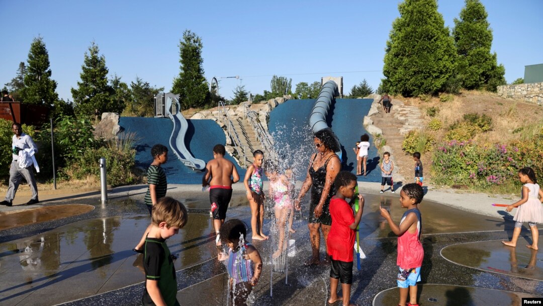 Orang dewasa dan anak-anak bermain air di Jefferson Park saat gelombang panas melanda Seattle, Washington, AS, 27 Juni 2021. (REUTERS/Karen Ducey)