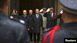 Le président français François Hollande, centre, le ministre de l'Intérieur Bernard Cazeneuve, deuxième à gauche, le maire de Paris Anne Hidalgo, à gauche, et le préfet de police Bernard Boucault, à droite, observant une minute de silence à la Préfecture de Paris, jeudi 8 janvier 2015.